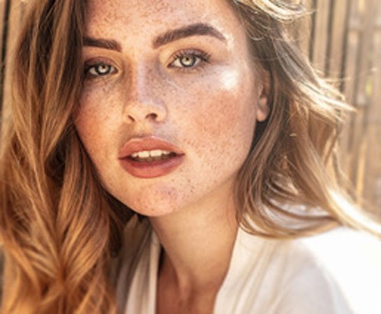 Woman with freckles and redhair in summer hairstyle