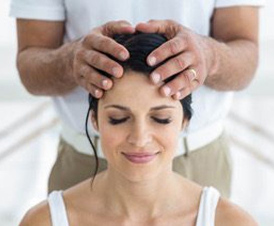 |Pretty woman receiving a head massage from masseur at home